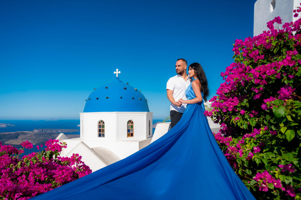 A rare scenery of Bougainvillea blooms with a blue domes church view during the warm seasons at Santorini.