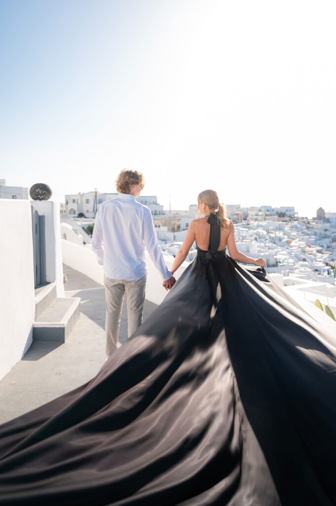 A couple holding hands and looking each other with white caves in the background.