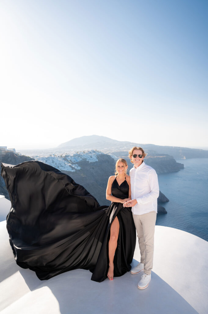 Couple standing together happy after engagement move with a caldera view at Thera