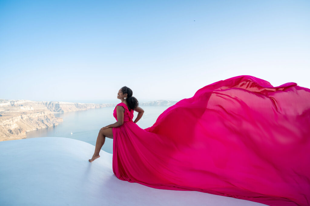 A portrait pose of a lady in fuchsia dress at Imerovigli Santorini
