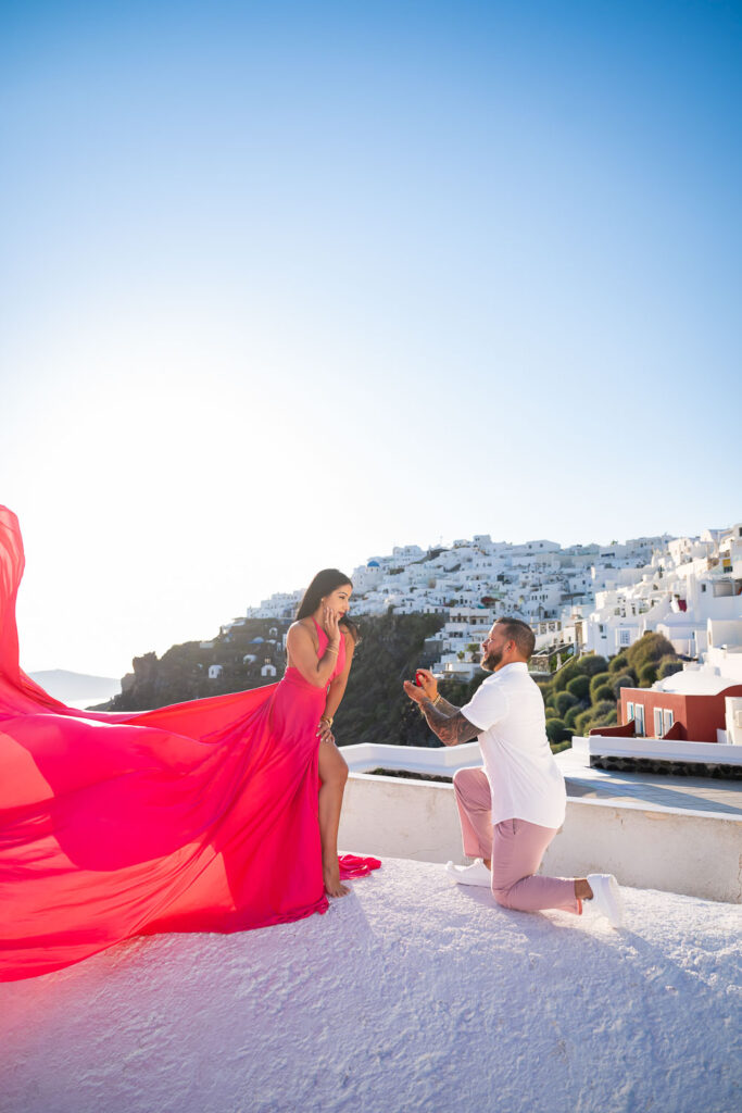 Man proposes to his girlfriend in a flying dress while she looks surprised